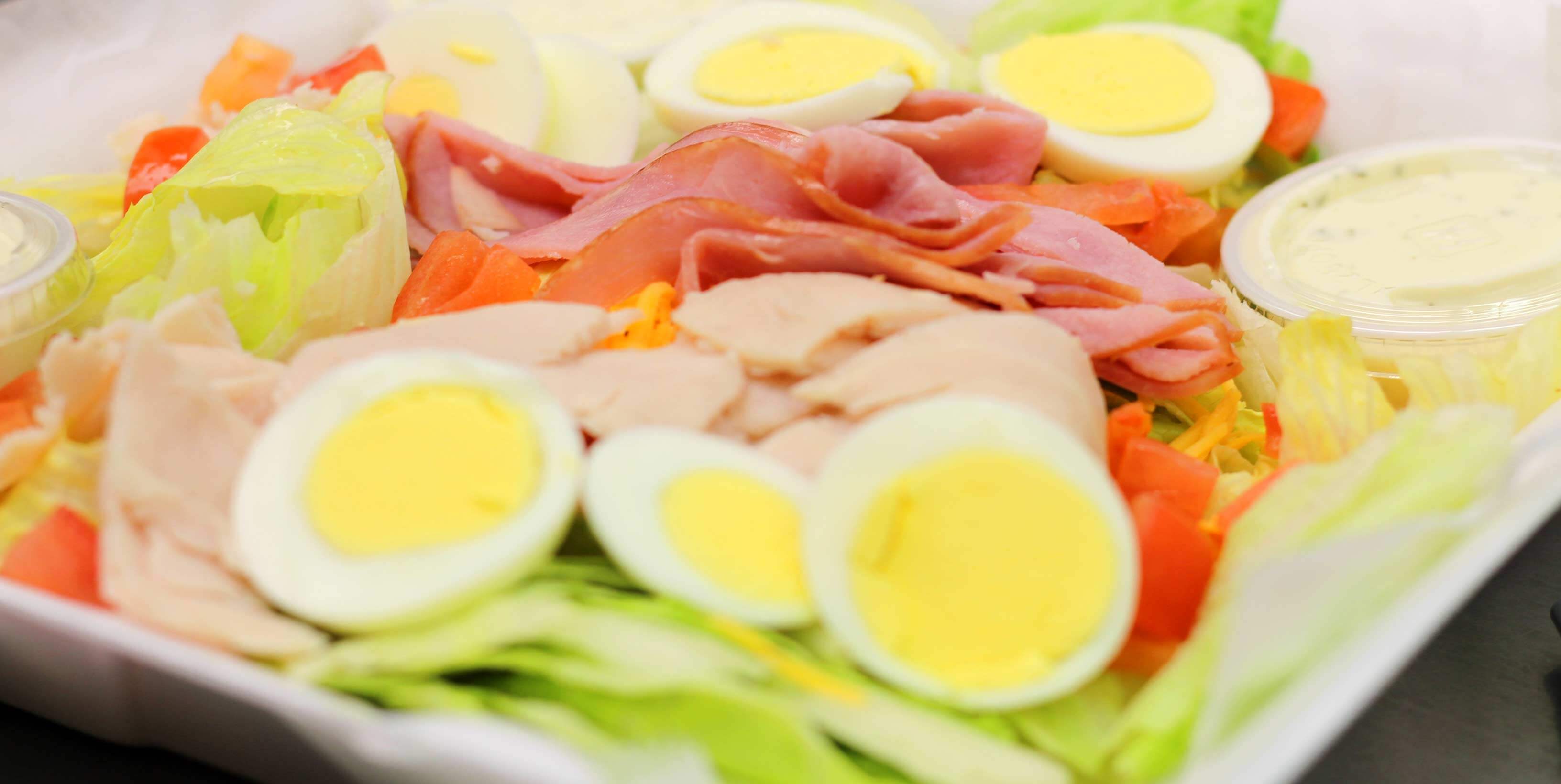 Cheif salad made up of sliced eggs, turkey, ham, bacon and lettuce
